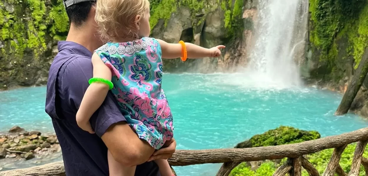 Little girl in tourquise waterfall in Costa Rica