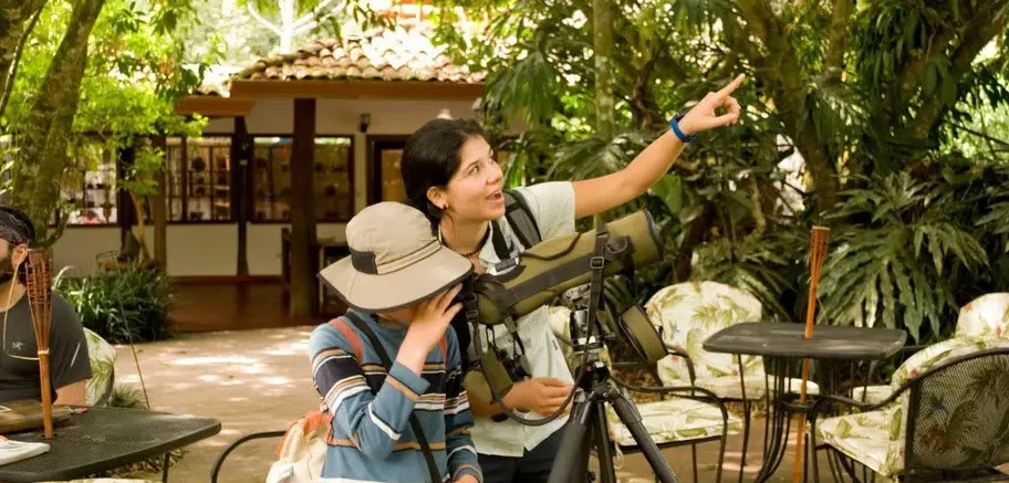 Kid using telescope in the rainforest Sarapiqui